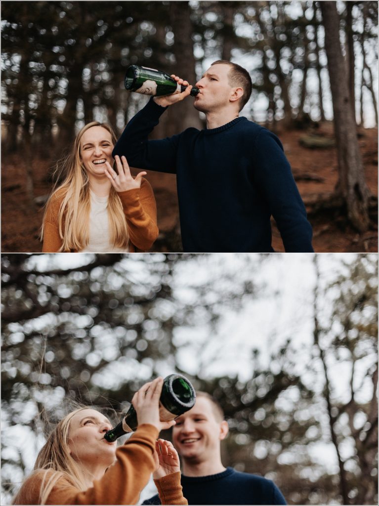 couple in blue and orange sweaters pop champagne at the middletown overlook for firefighter engagement photos