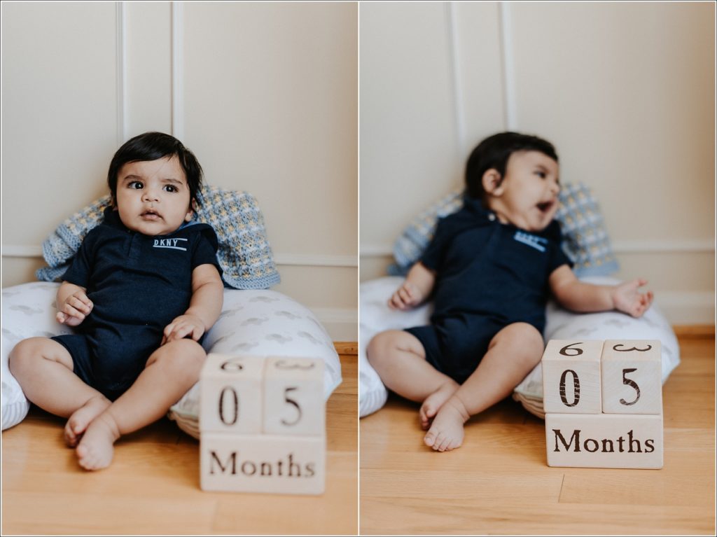 baby in dark blue onesie poses by blocks that say 5 months