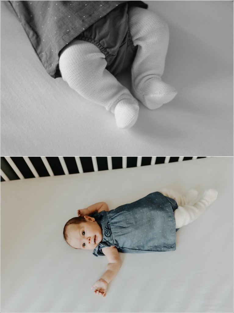 newborn baby wearing white leggings and blue jean dress romper in crib