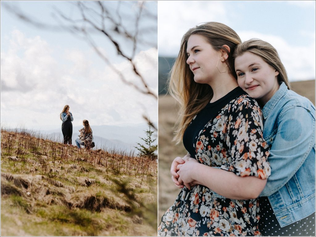 surprise proposal on mountaintop with woman embracing her fiance wearing jean jacket and floral shirt
