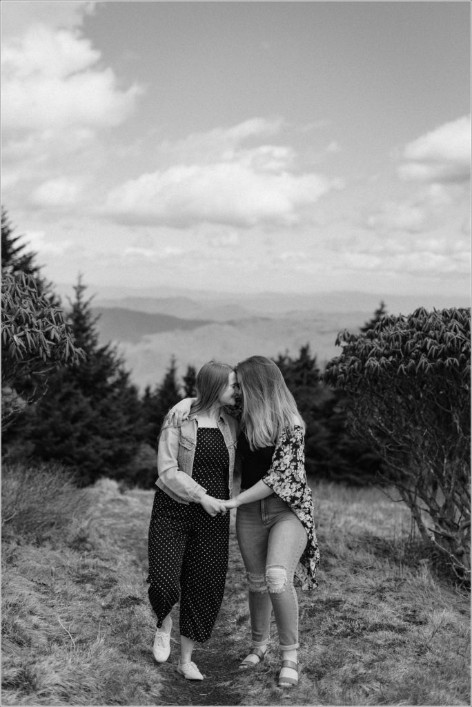 black and white photo of two women walking together on roan mountain for surprise proposal