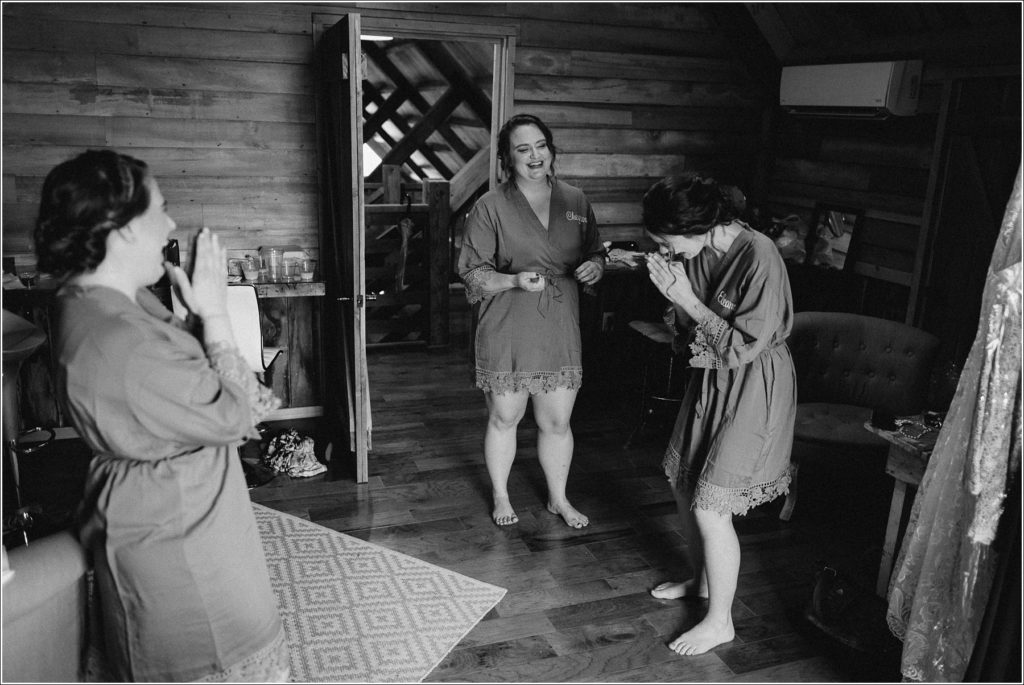 bridesmaids laugh together at the barns at chip ridge in black and white