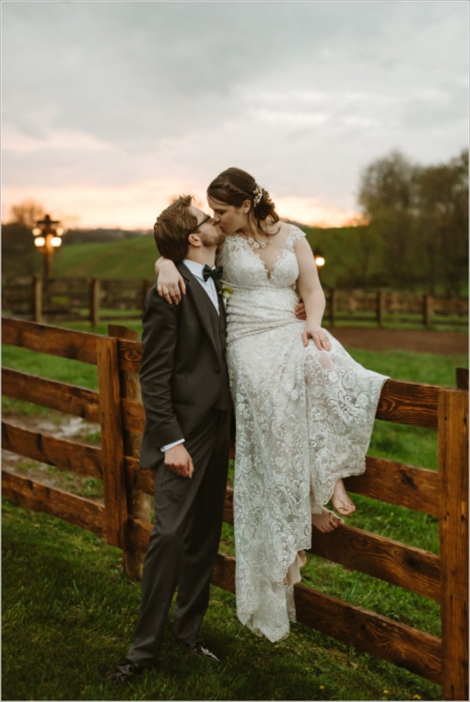 a newlywed couple kisses at the barns at chip ridge at sunset