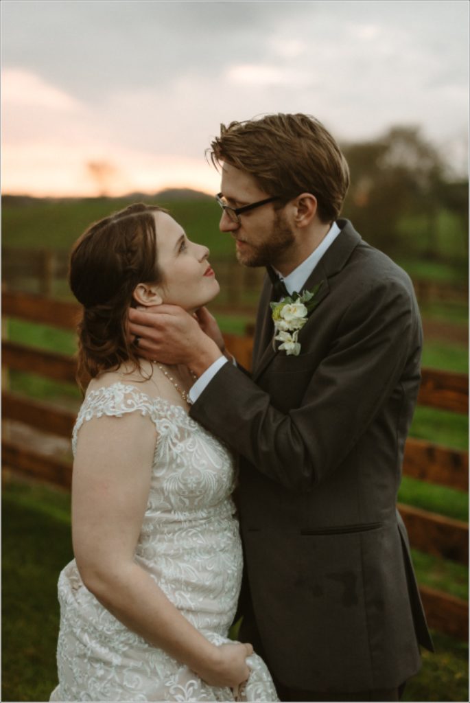 a couple holds one another in wedding dress and suit at the barns at chip ridge at sunset