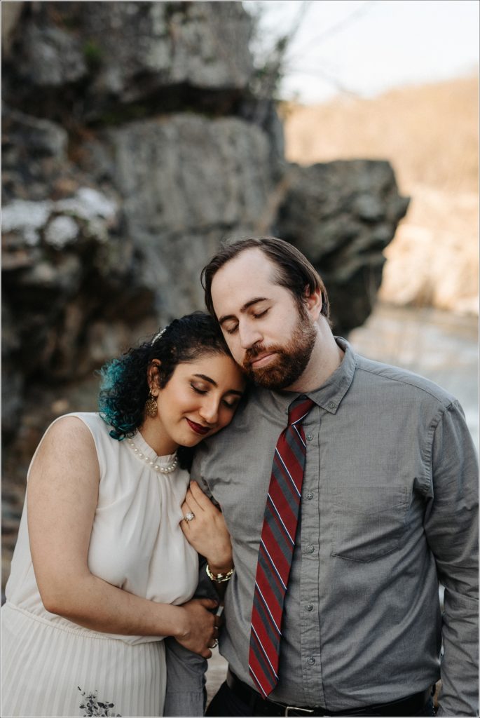 couple hugs at great falls virginia for photoshoot in white dress and grey button up shirt