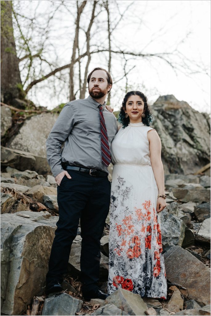 couple snuggles up at great falls virginia for photoshoot in white dress and grey button up shirt
