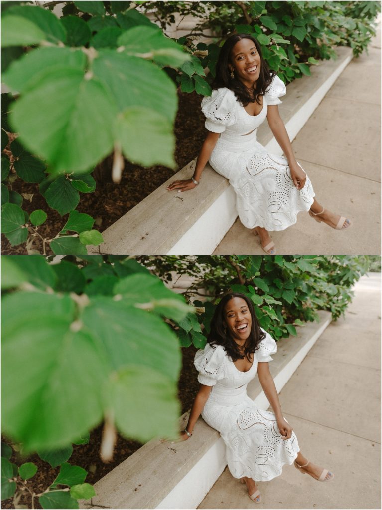 laughing black woman in graduation photos in front of kogod school of business in white dress