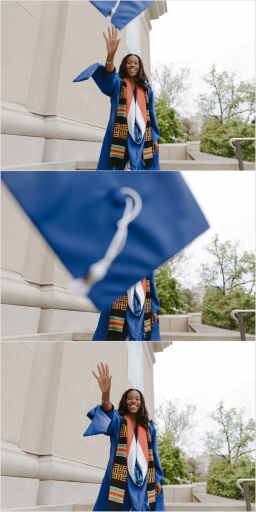 american university grad in blue cap and gown throws hat at camera