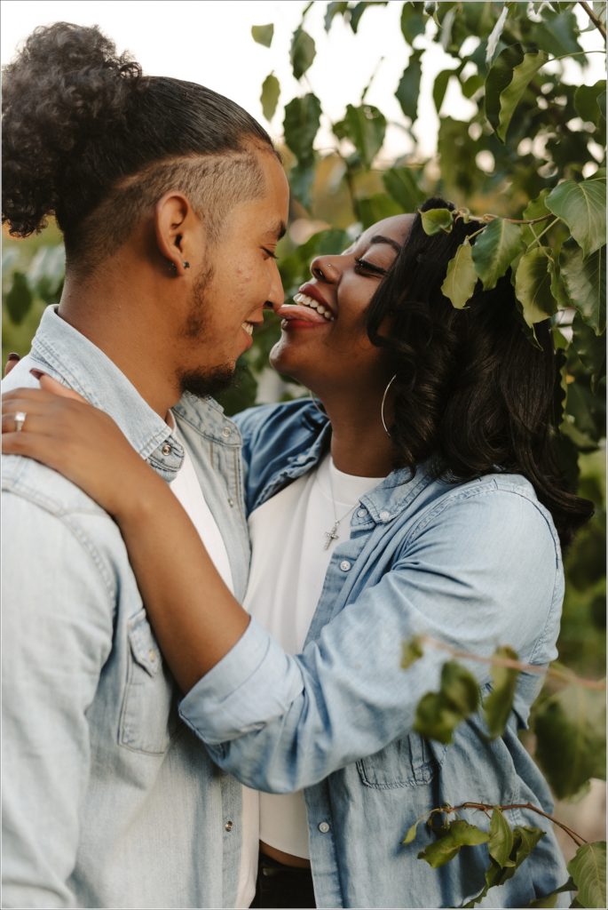 woman licks fiance's nose in engagement photos in georgetown wearing jean material