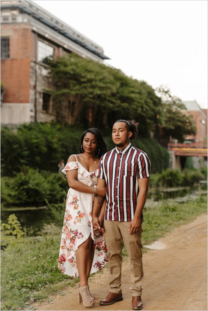 couple poses for dc engagement photographer in georgetown in floral dress and striped shirt