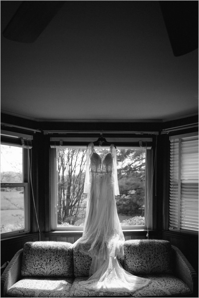 hanging bhldn lace dress in window of dimly lit house