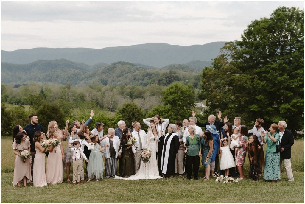wedding party celebrates in group photo in front of the mountains in bristol tn backyard wedding with abingdon photographer