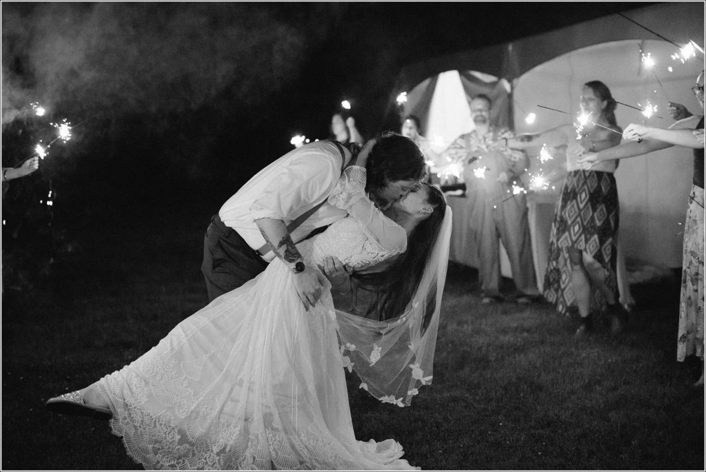 couple kisses in between sparkler exit in backyard tennessee wedding with abingdon photographer