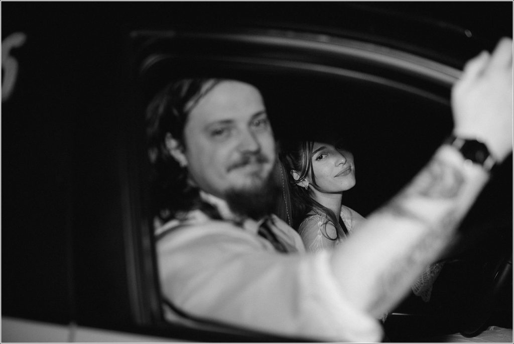 couple poses like movie stars in their car in black and white image with abingdon photographer