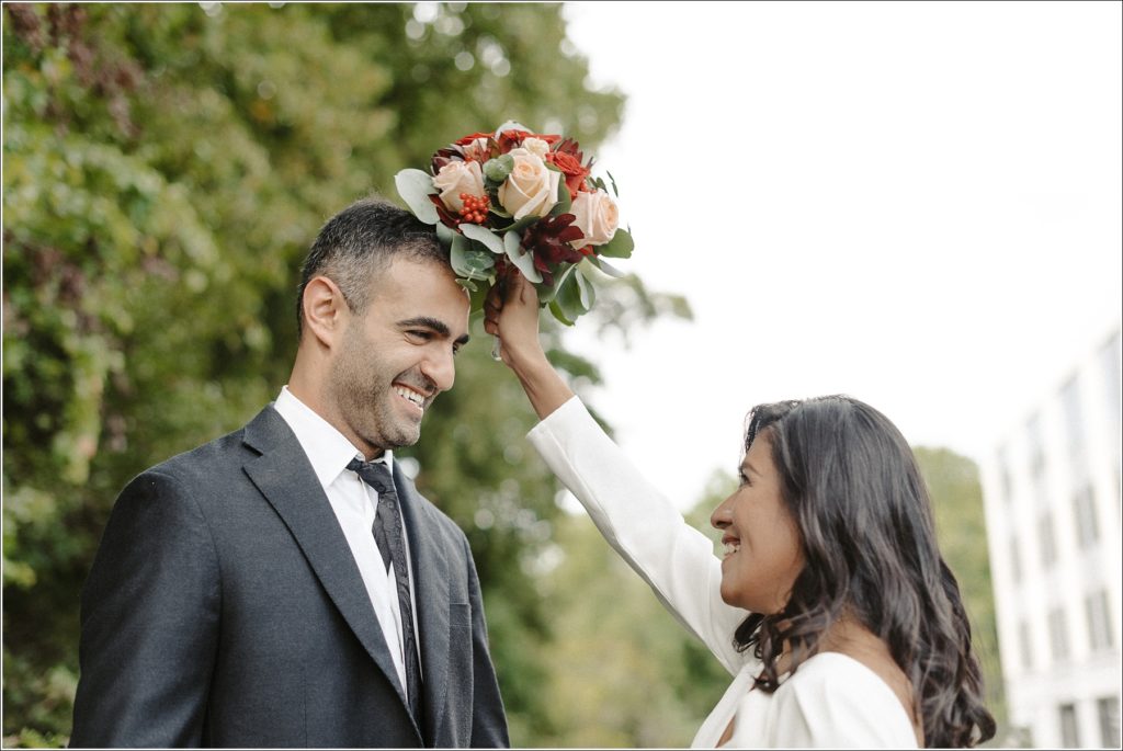 bride puts bouquet on grooms head at circuit court of howard county