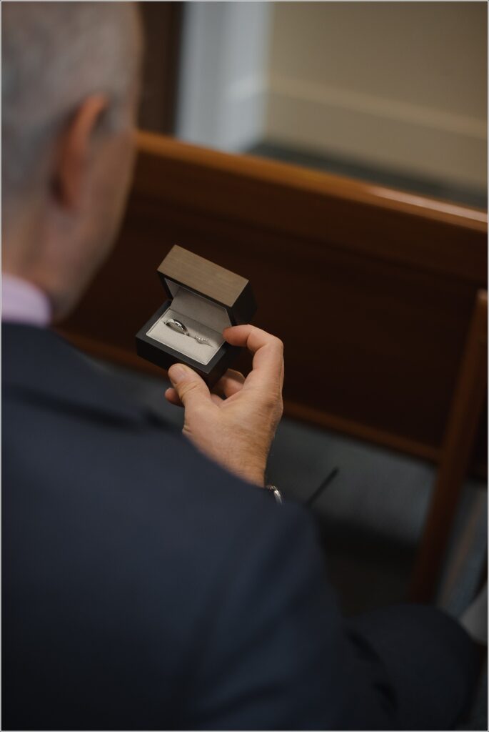 hand of a man holds box with wedding ring in it