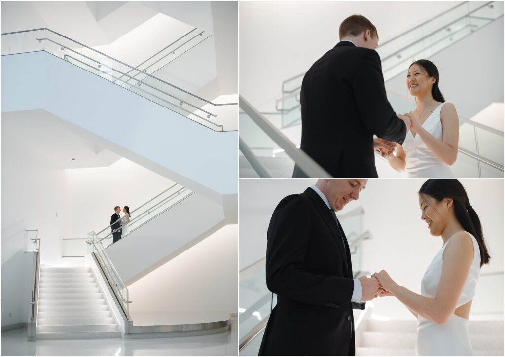 a woman in a white white dress and man in black suit stand on stairs at their howard county courthouse wedding