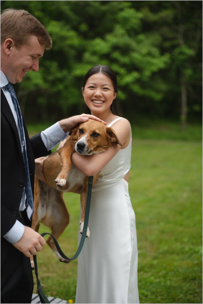 a bride and groom hold their puppy